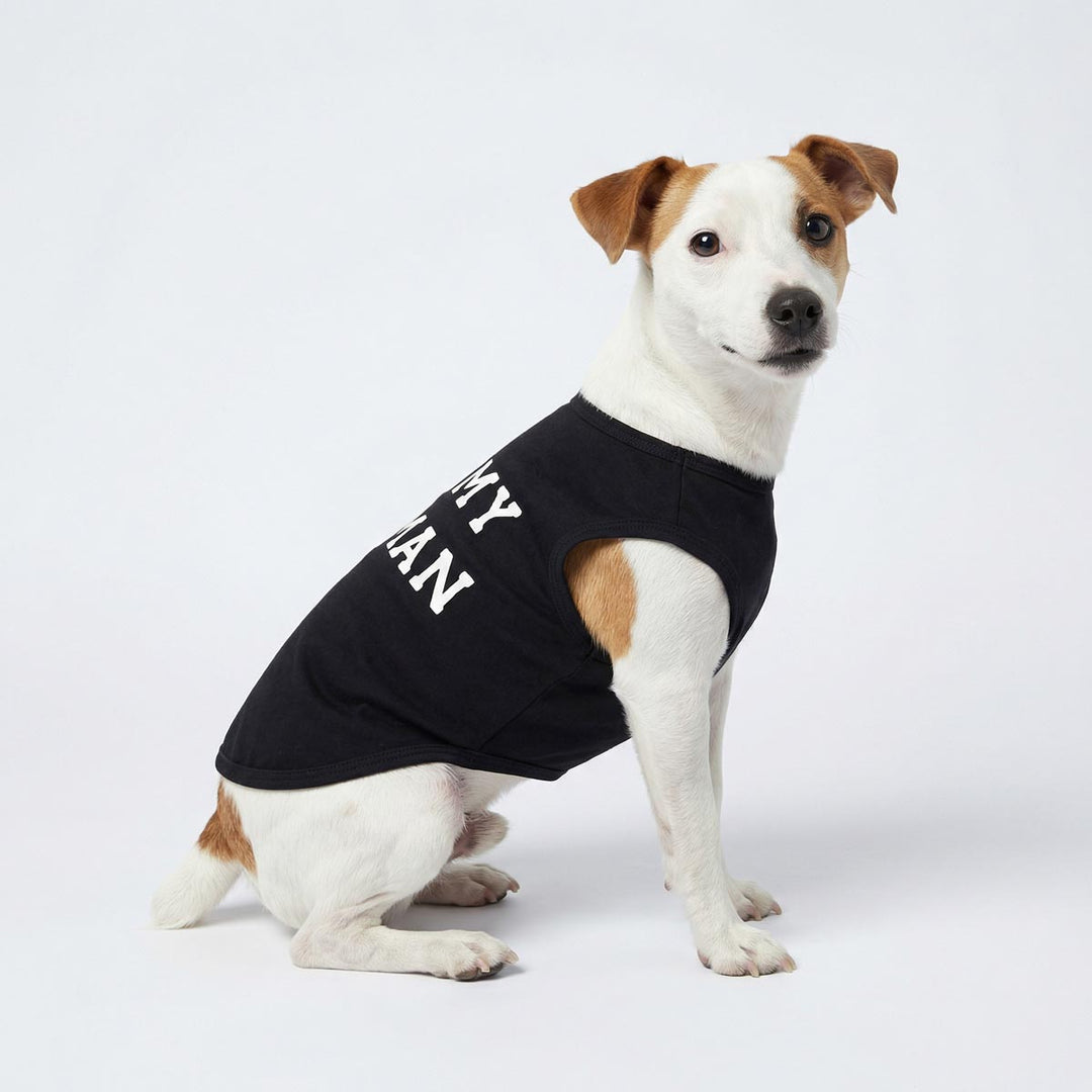 Dog wears black dog tank top with bold I love my human lettering, sitting on white background.