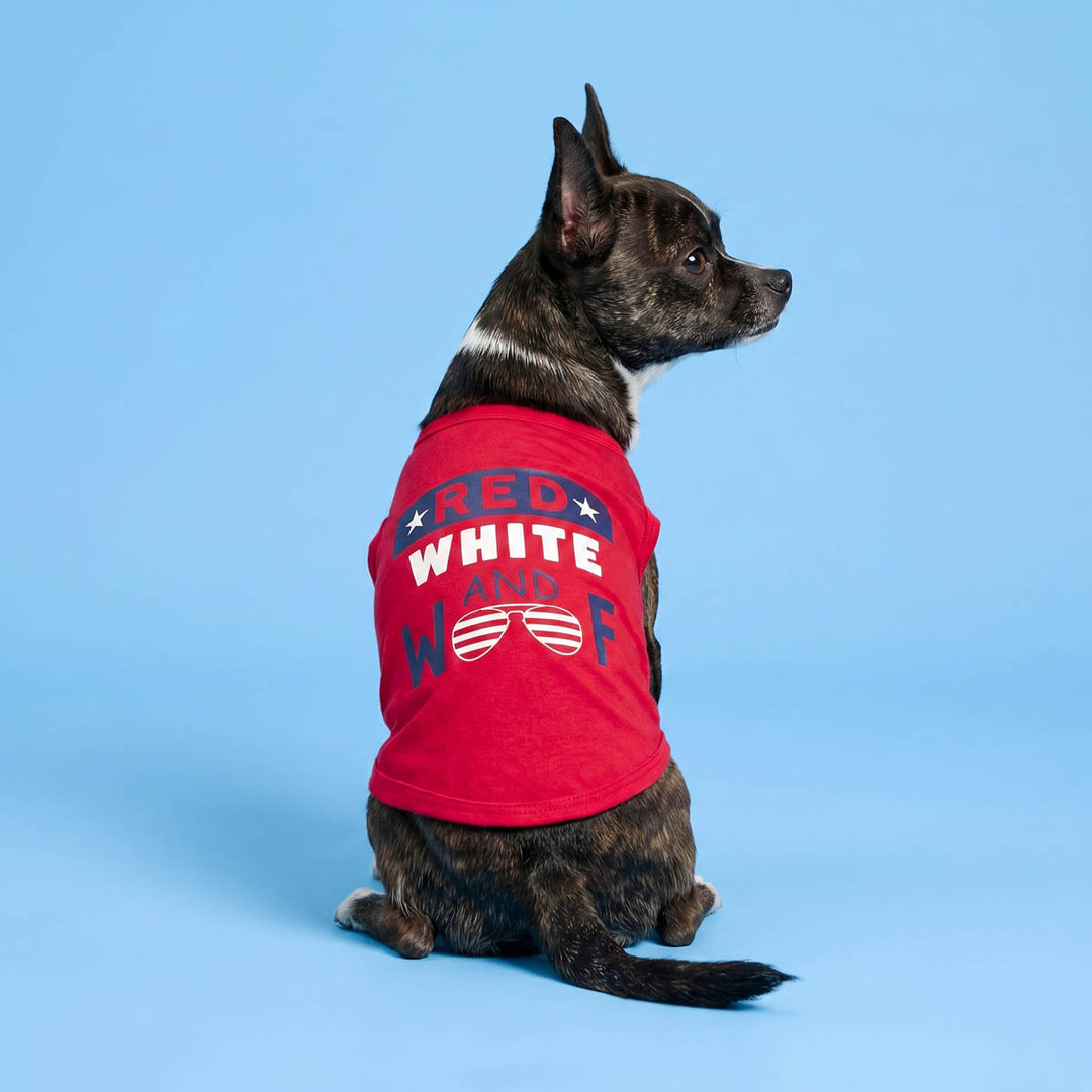 Back view of dog sitting on a blue background in a sleevess dog tshirt with patriotic 'Red, white and woof' lettering