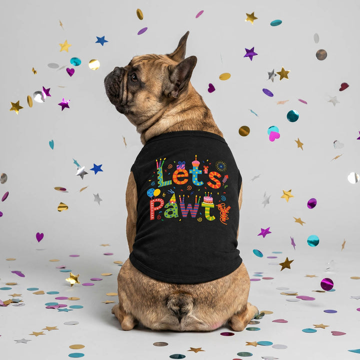Dog sitting on a gray background with confetti in birthday themed shirt for dogs.