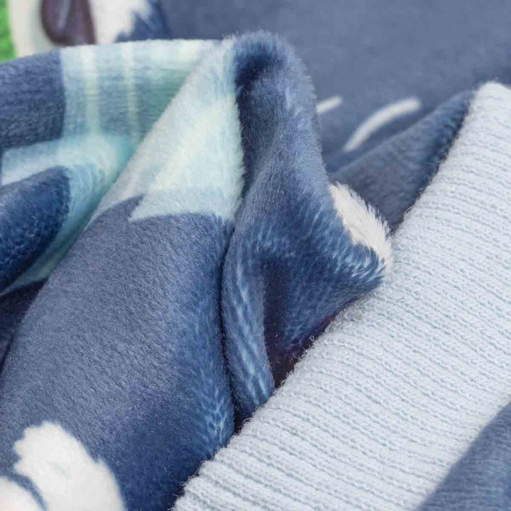 Close-up of a soft fleece dog onesie with a blue and white pattern, showing the plush texture and folded edges