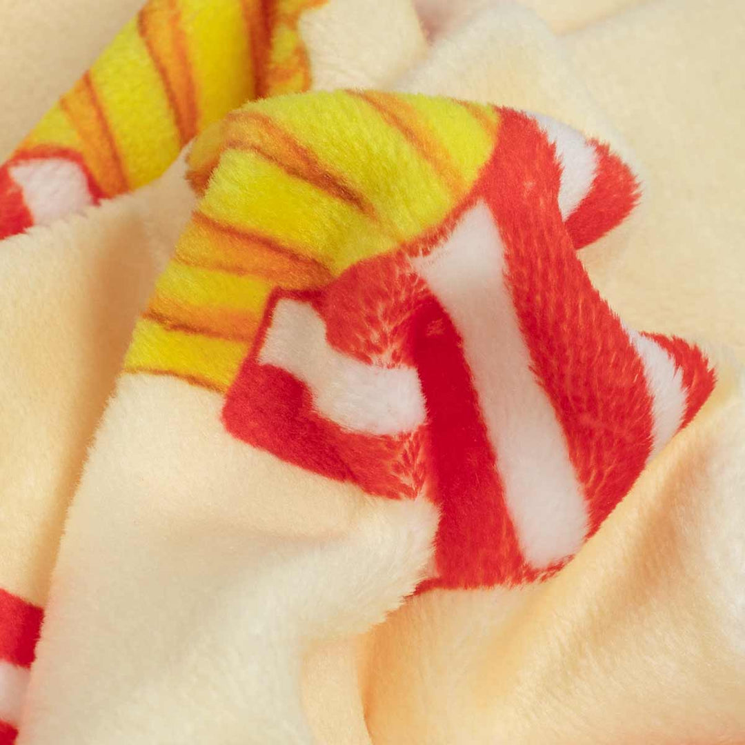 Close-up of a plush fleece dog pajamas with a french fries pattern, featuring red and white stripes on a pale yellow background