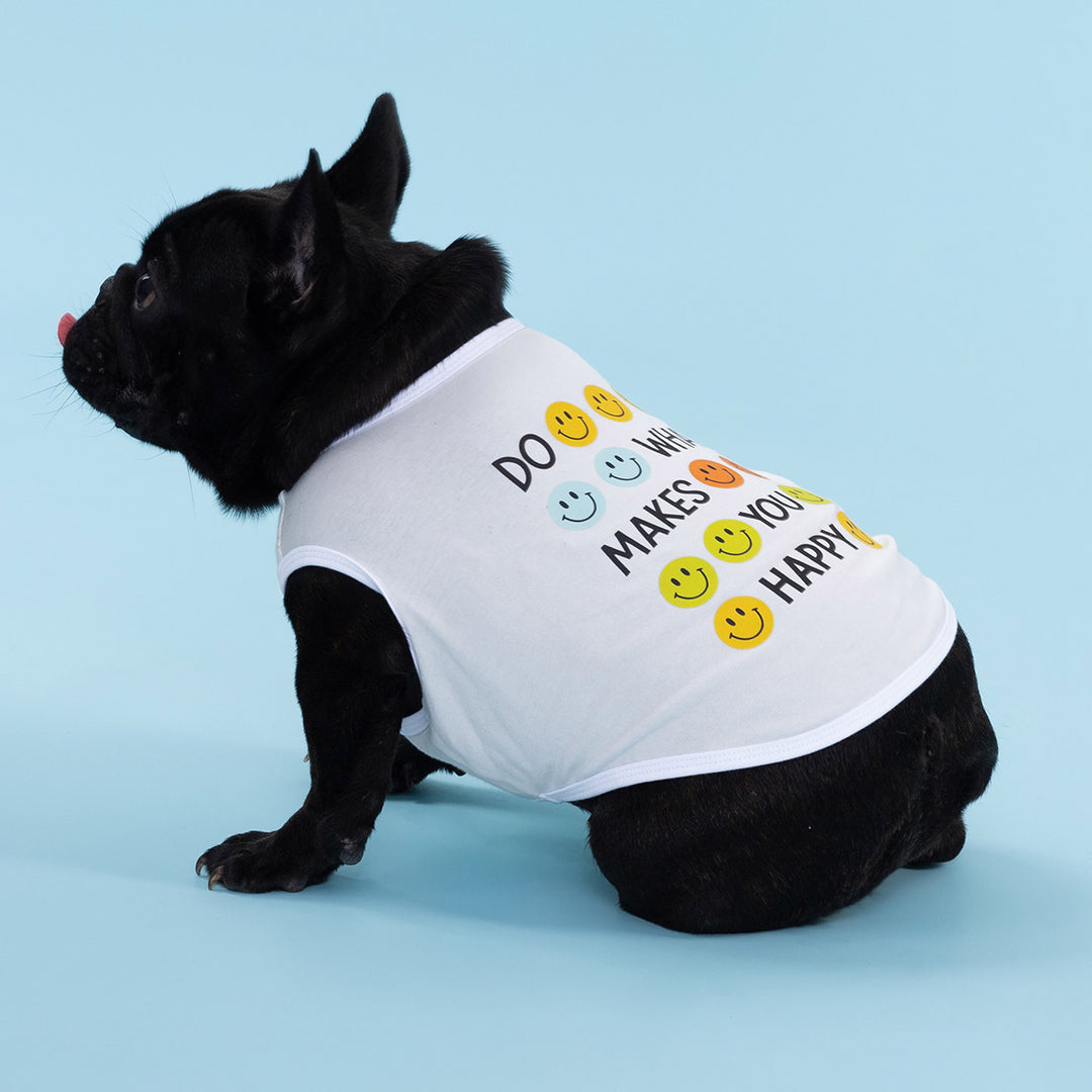 Black French Bulldog sitting in a white dog shirt with colorful smiley face print
