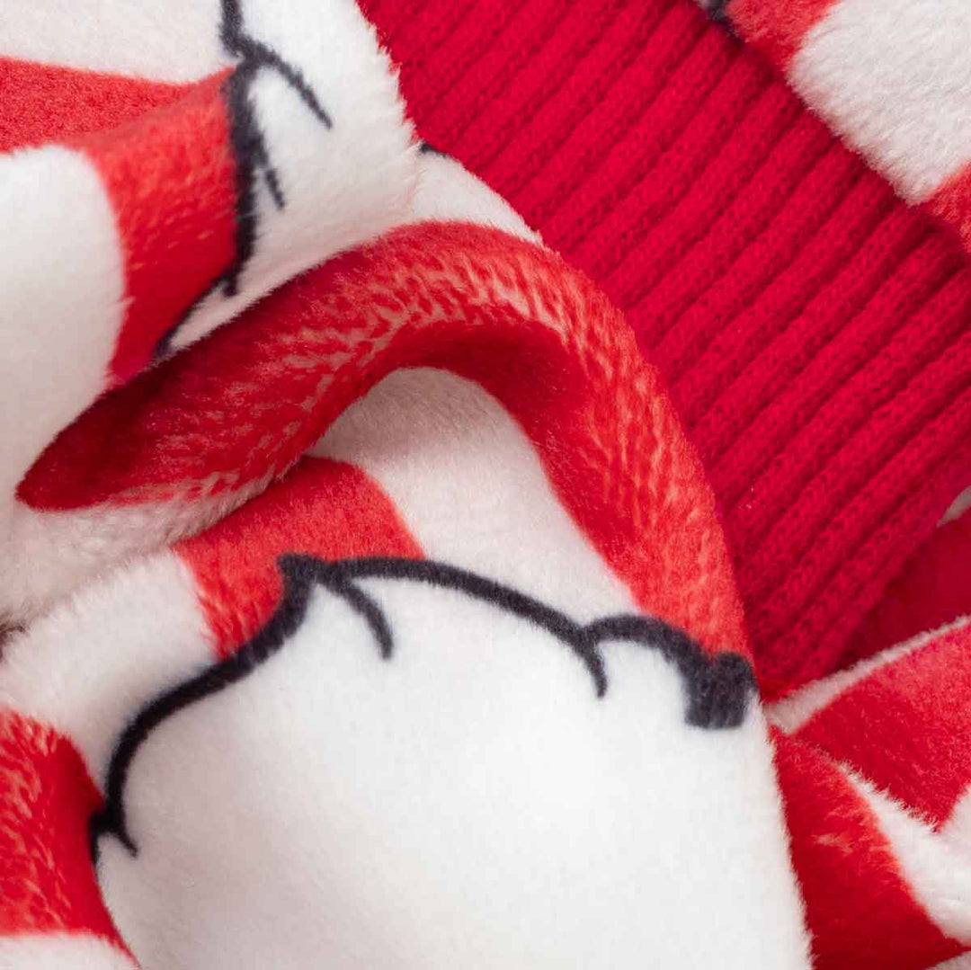 Close-up of a Christmas pajamas for dogs featuring red and white stripes, a red ribbed knit section, and Santa Claus prints