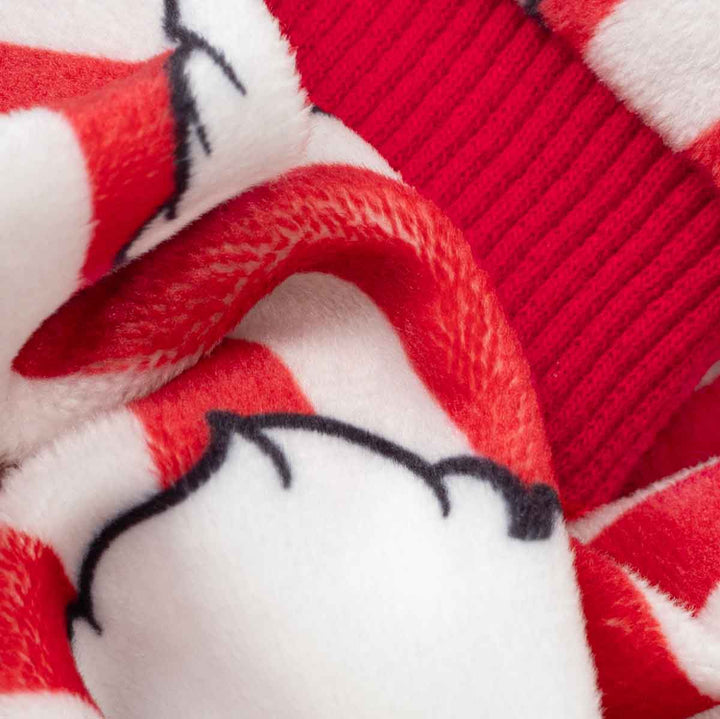 Close-up of a Christmas pajamas for dogs featuring red and white stripes, a red ribbed knit section, and Santa Claus prints