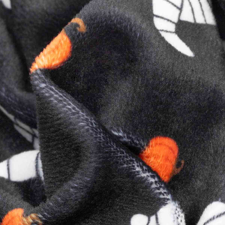 Close-up of a dog onesie with orange  pumpkin and  white mummy prints