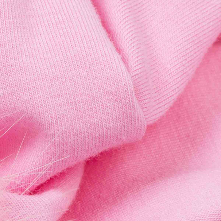 Close-up of soft pink knit fabric on Halloween dog t-shirt with visible texture and a few loose fibers