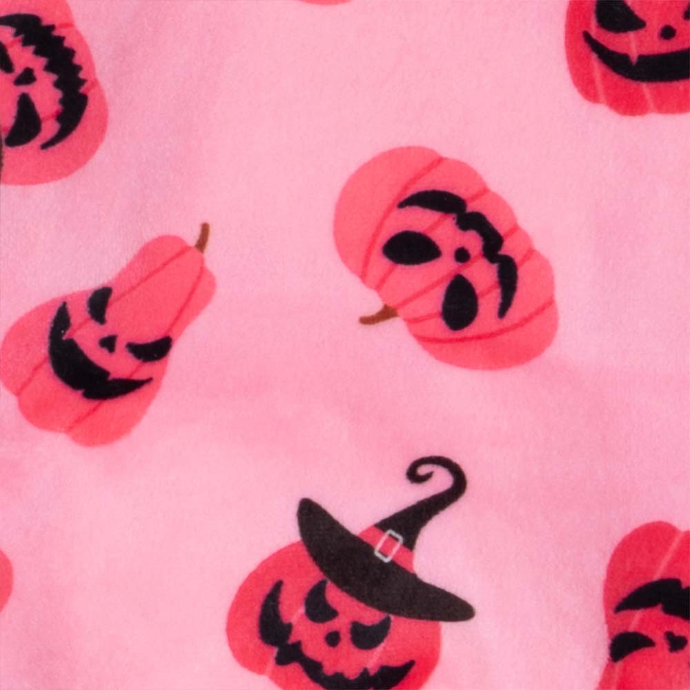Pink dog pajama fabric detail: soft polyester with playful Halloween pumpkin and witch hat patterns.