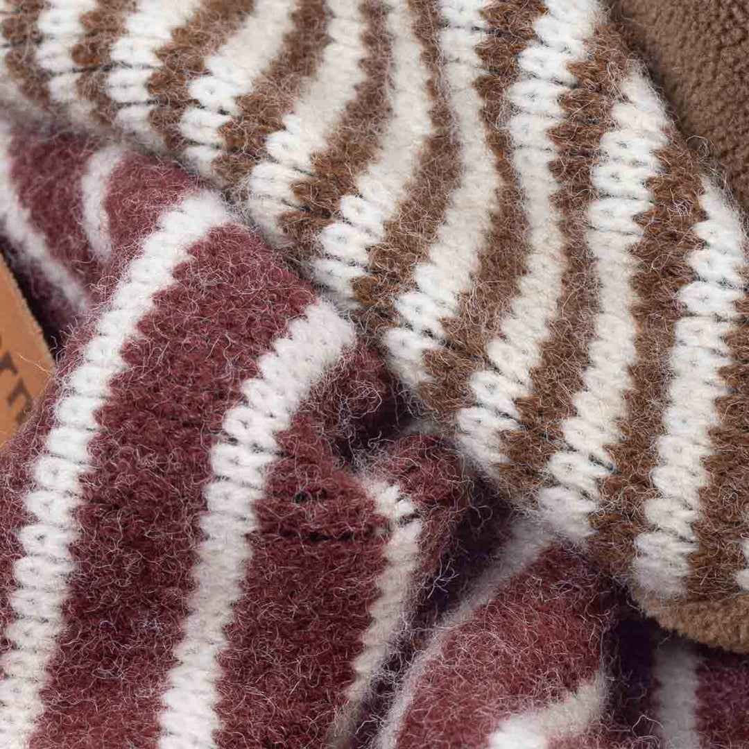 Close-up of a fuzzy knit textile with alternating vertical stripes in brown, cream, and muted burgundy