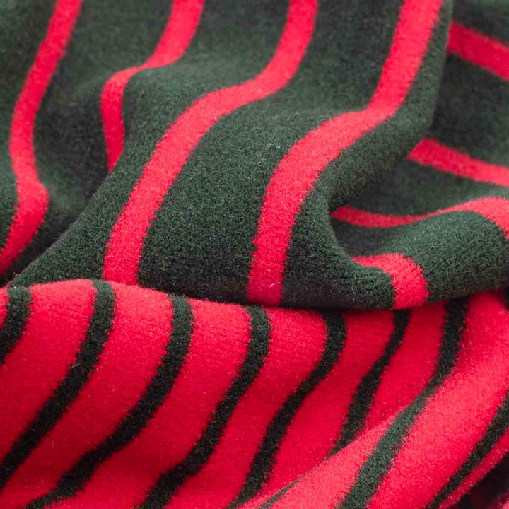 Close-up of a plush fleece fabric with bold red and dark green wavy stripes