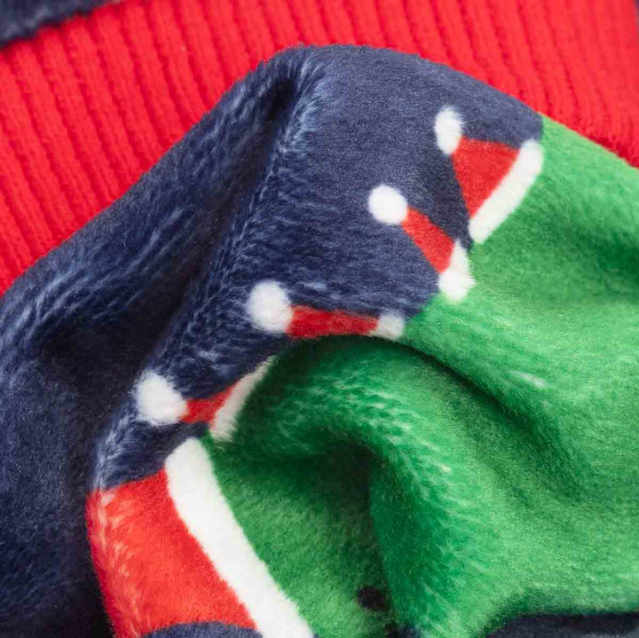 Close-up of a plush knit fabric with a holiday pattern, showing navy blue, green, red, and white sections