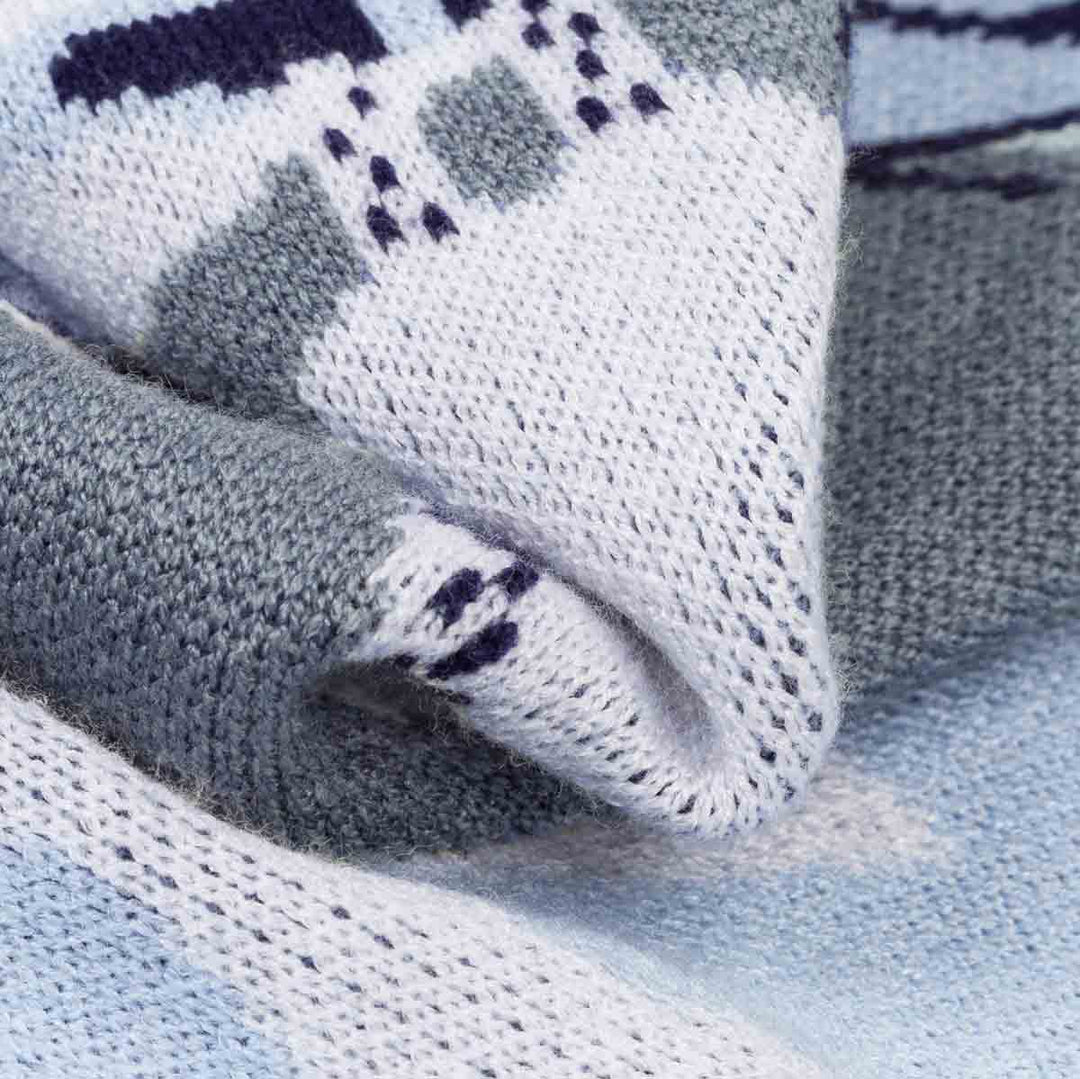 Close-up of a knitted textile with a white base, and yeti print, showing the knit texture and folded fabric