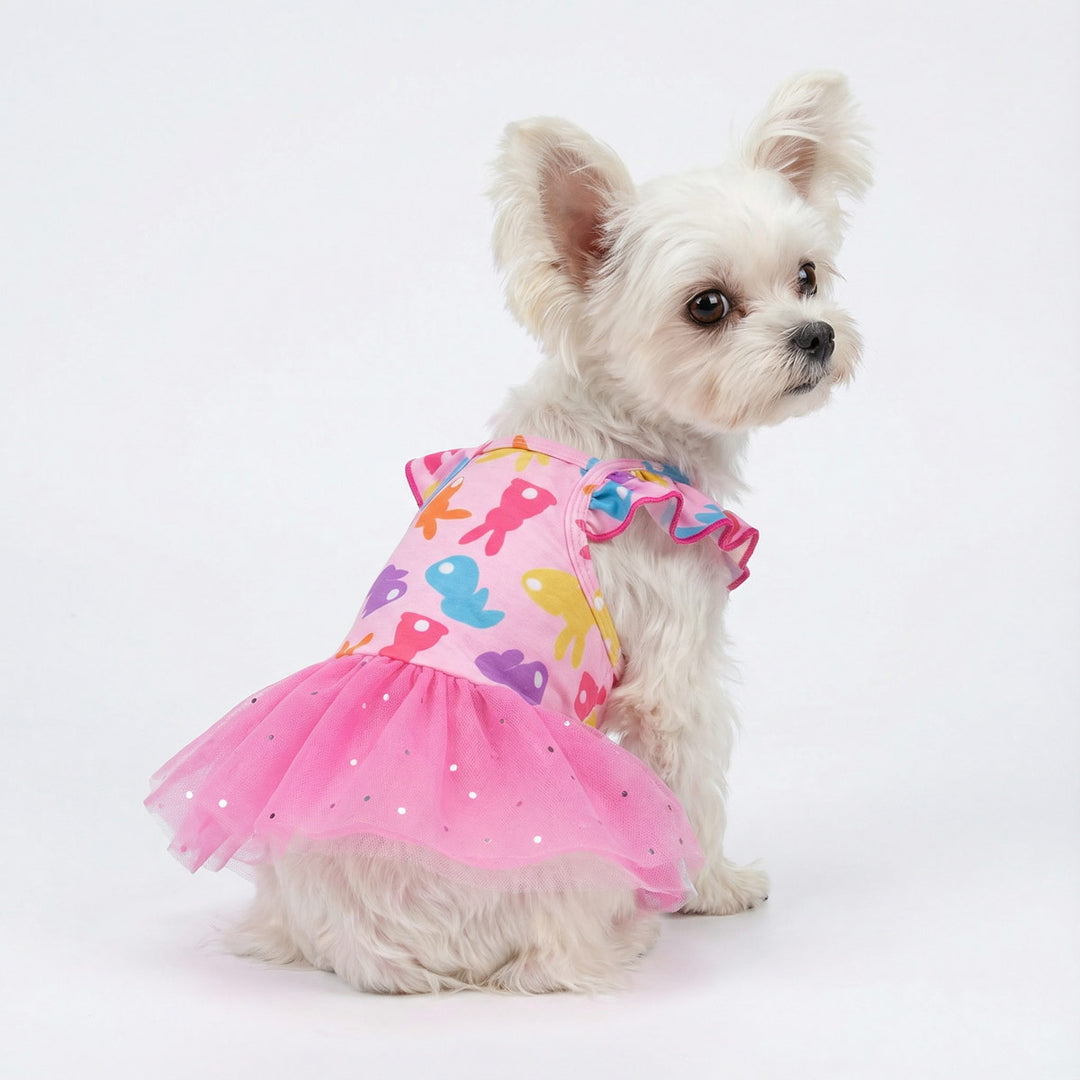 Cute white dog wearing a ruffle dog Easter dress with colorful bunny prints