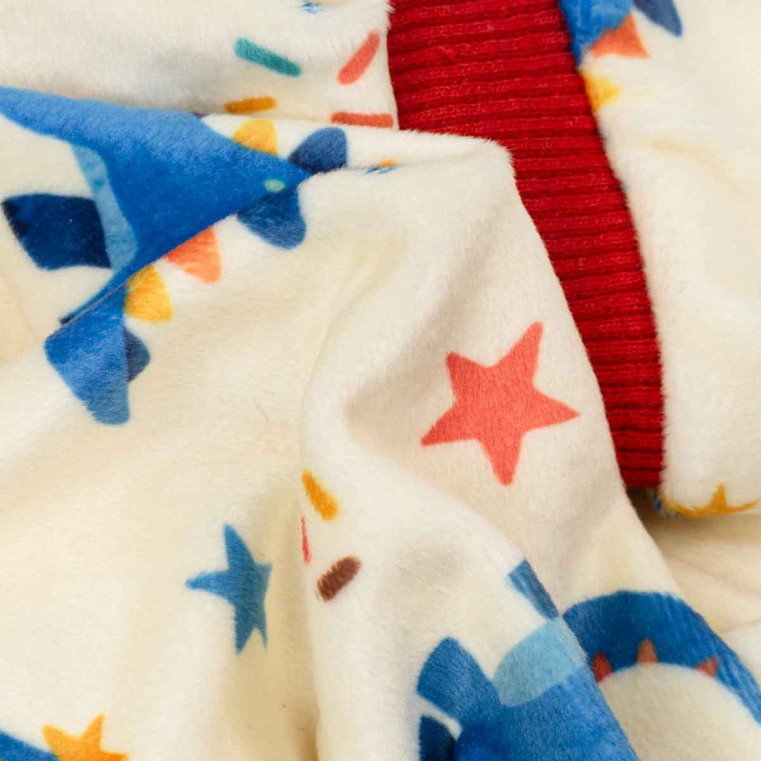 Close-up of a soft fabric with colorful star patterns and a red border