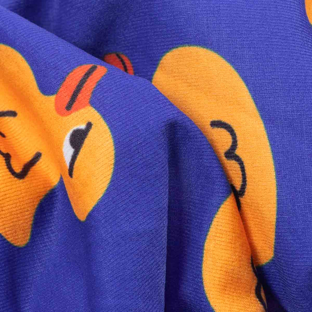 Close-up of a blue fabric with orange duck patterns