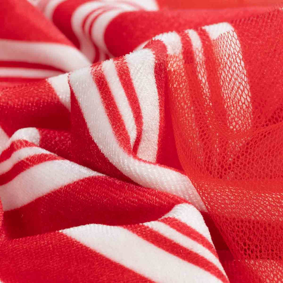Close-up of red and white striped tulle fabric of dog xmas dress with a soft plush lining visible along the folds