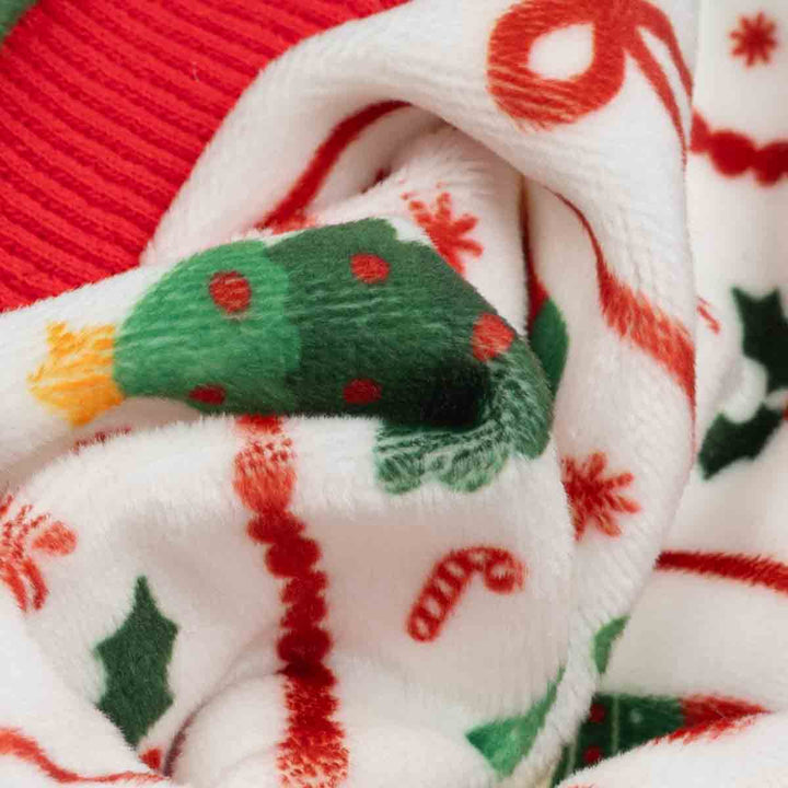 Close up of the fabric on dog Christmas pajamas with Christmas tree, bow and candy cane