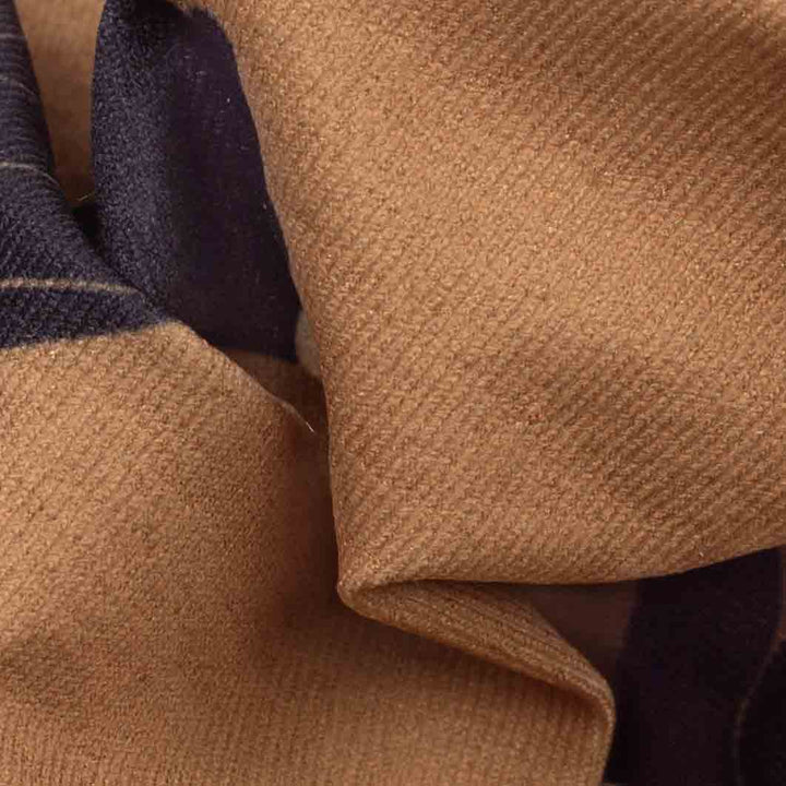 Close-up of fabric of dog t-shirt with a tan and dark navy check pattern, showing the fabric texture and fold details
