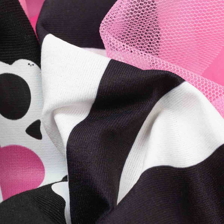 Close-up of a fabric product showing bold black and white stripes with a bright pink mesh section and a pirate print