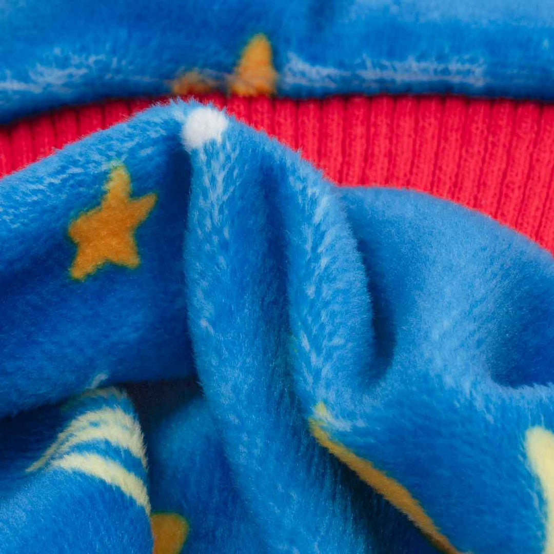 Close-up of a plush blue fabric with yellow star patterns and a red ribbed knit section