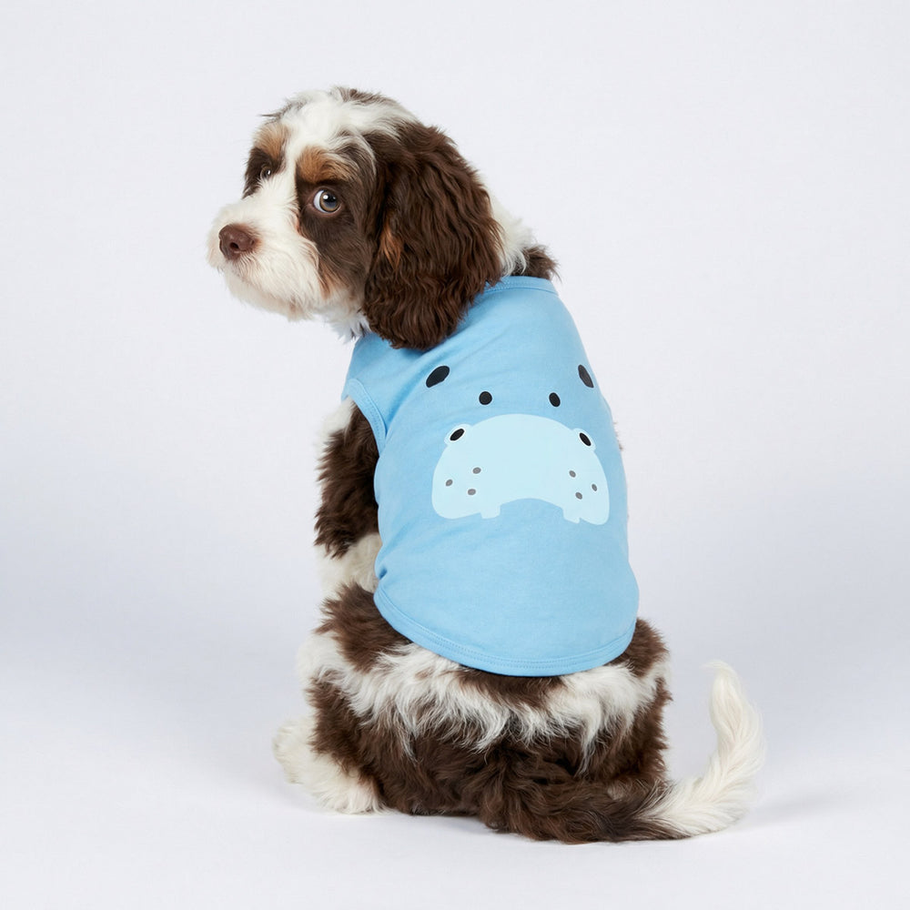 Fluffy dog looking back with a blue dog t-shirt with a hippo face