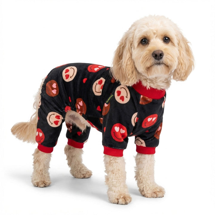 Dog wearing a black dog pajama with red and brown heart eyes patterns on a white background