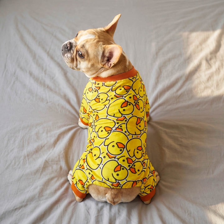 French Bulldog sitting on the bed with a rubber duck dog pjs