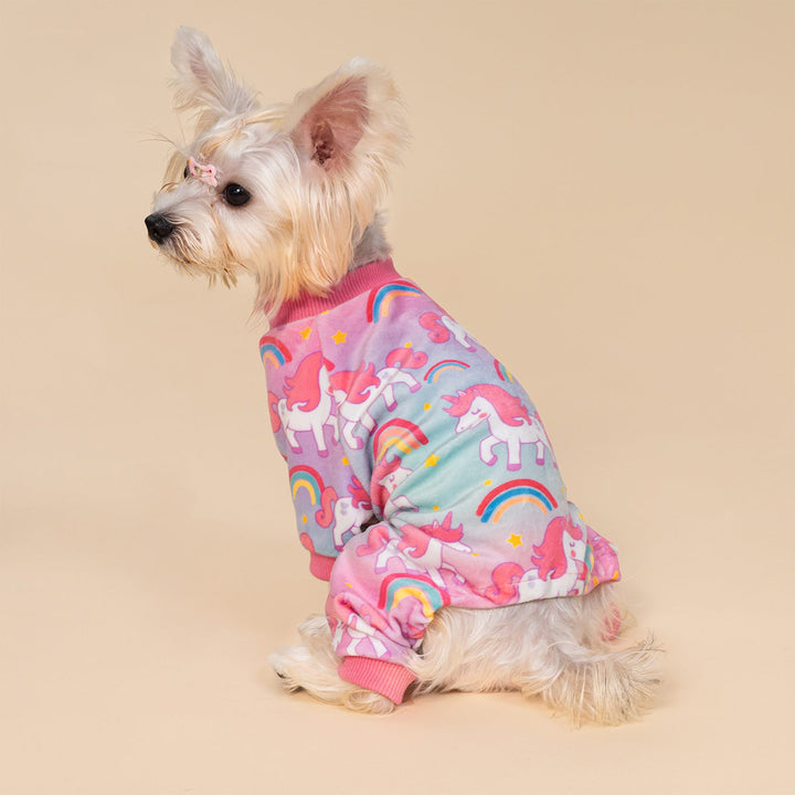 Dog wearing bright unicorn dog pjs with playful rainbow graphics