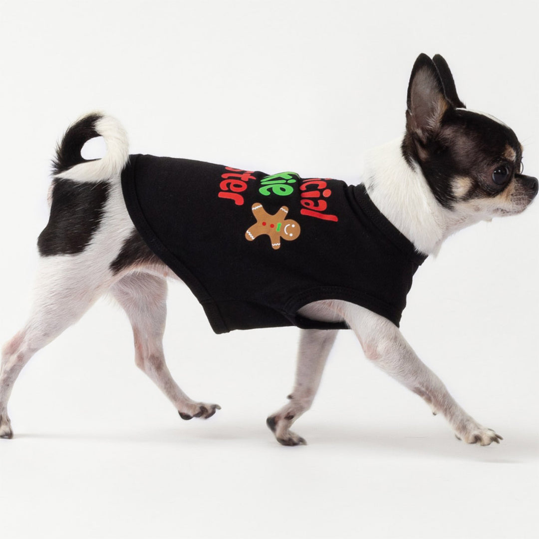 Cute dog dressed in festive black Christmas dog tank top featuring gingerbread cookie and holiday lettering.