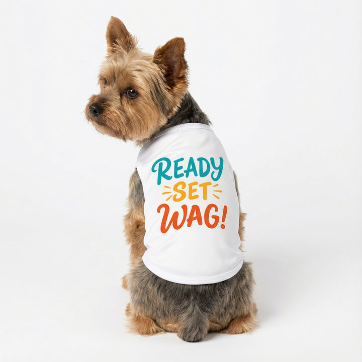 Yorkshire terrier sitting in white dog tank top with colorful 'Ready Set Wag!' lettering