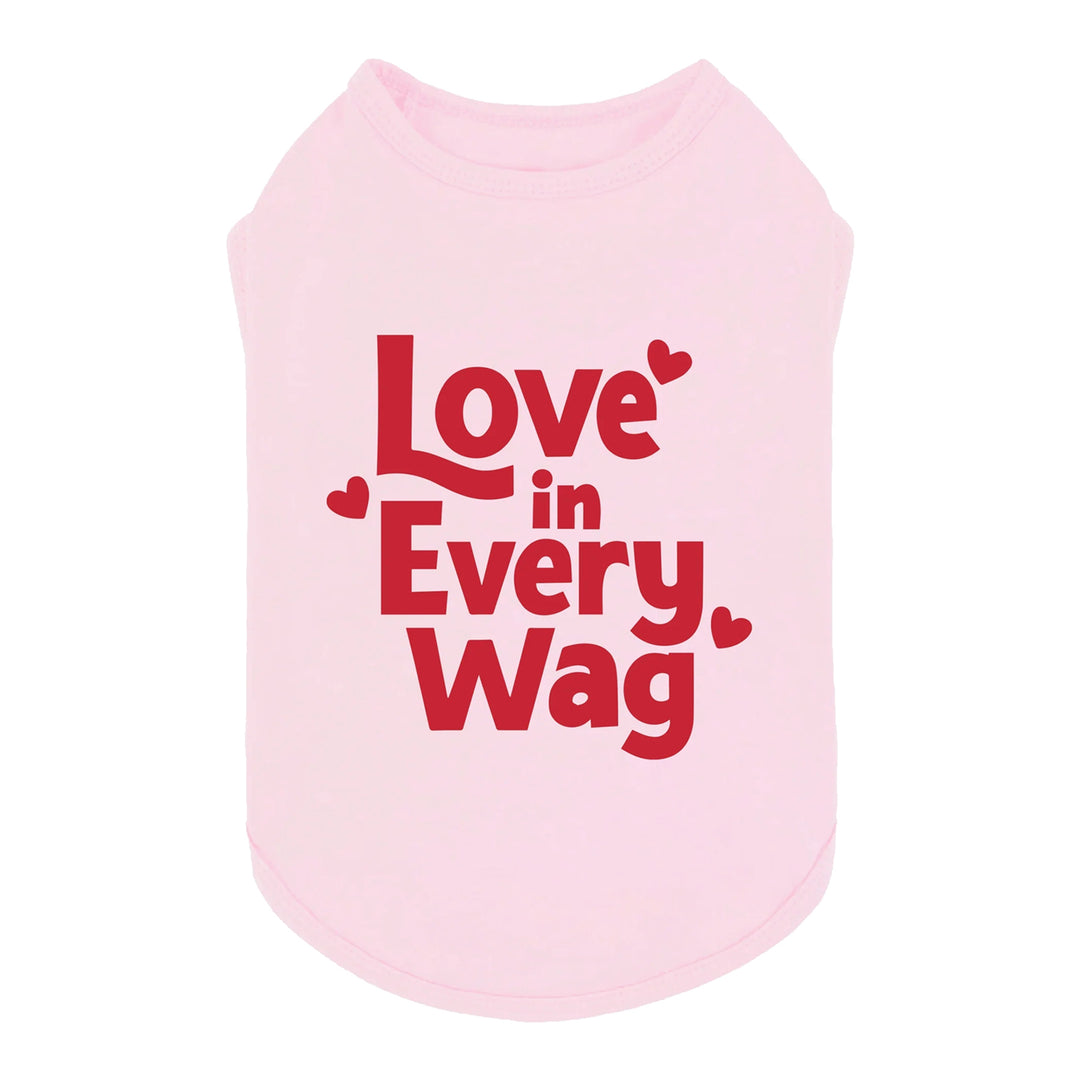 Pink dog shirt with red “Love in Every Wag” text and heart graphics, made from soft cotton fabric.