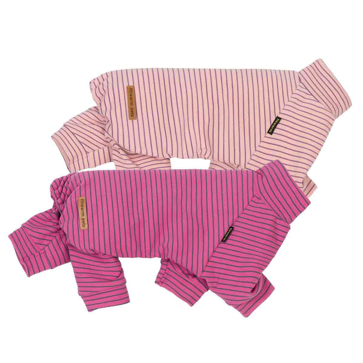 Side view of cozy 2 pack dog striped onesie, one in light pink and one in bright magenta, laid flat on a white background