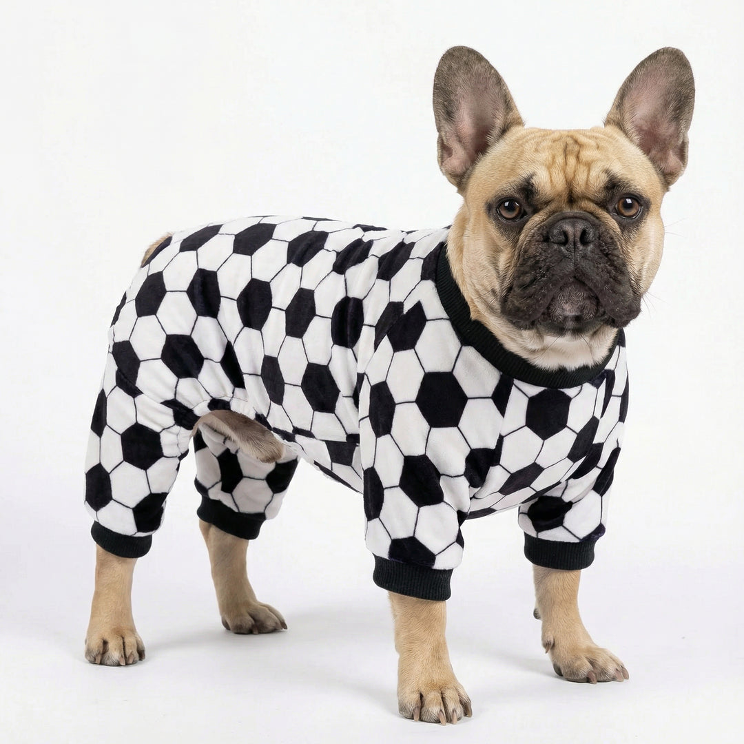 Dog wearing soccer print dog pajamas with black and white ball pattern