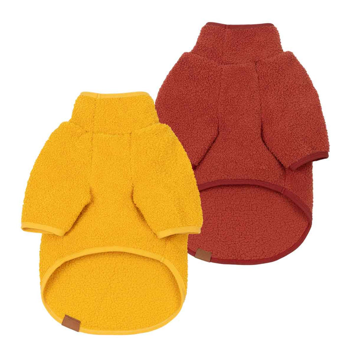 Two dog fleece sweaters shown on a plain white background, one in mustard yellow and one in rust red