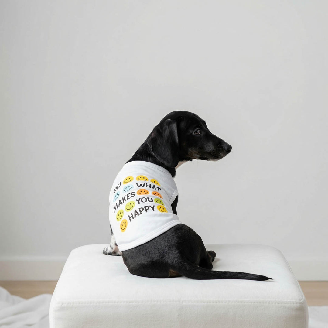 Black Dachshund lying on a pad with a white shirt for dogs with smiley face print and lettering