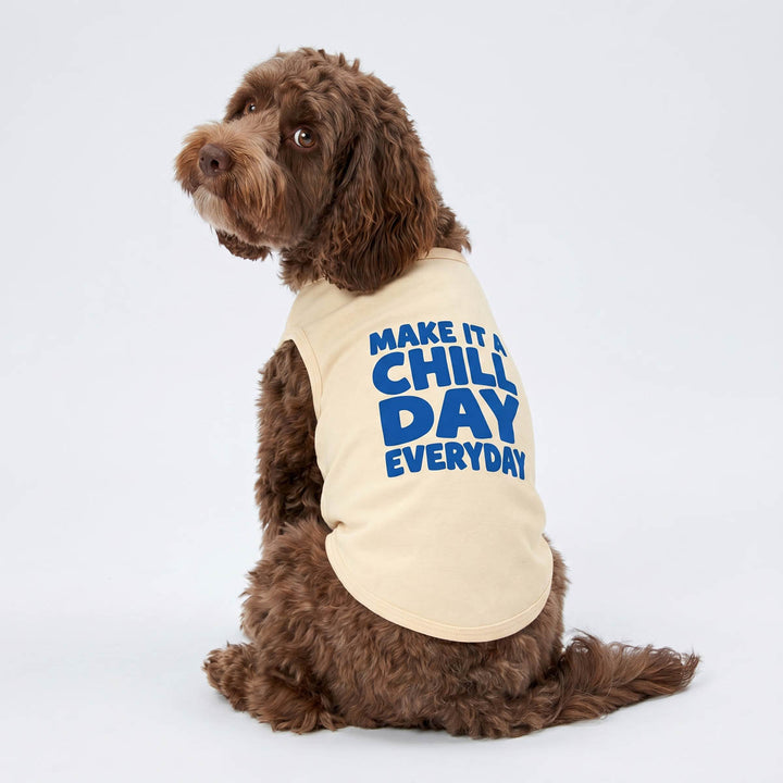 Dog wearing a beige shirt for dogs with blue 'make it a chill day everyday' lettering on a white background