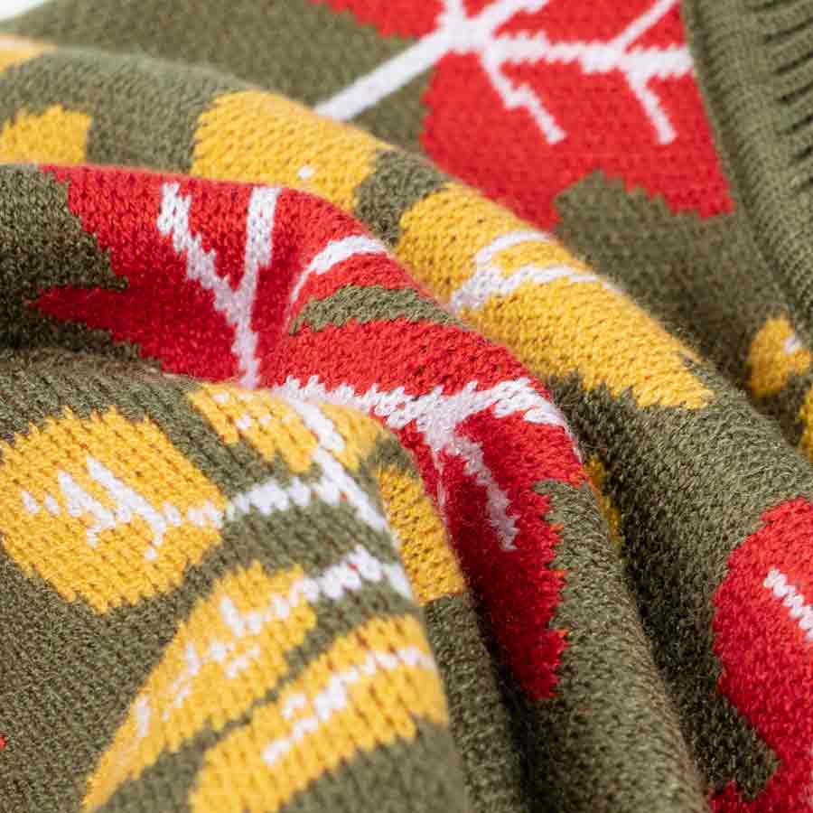 Close-up of a knitted fabric with red, yellow, and green patterns.