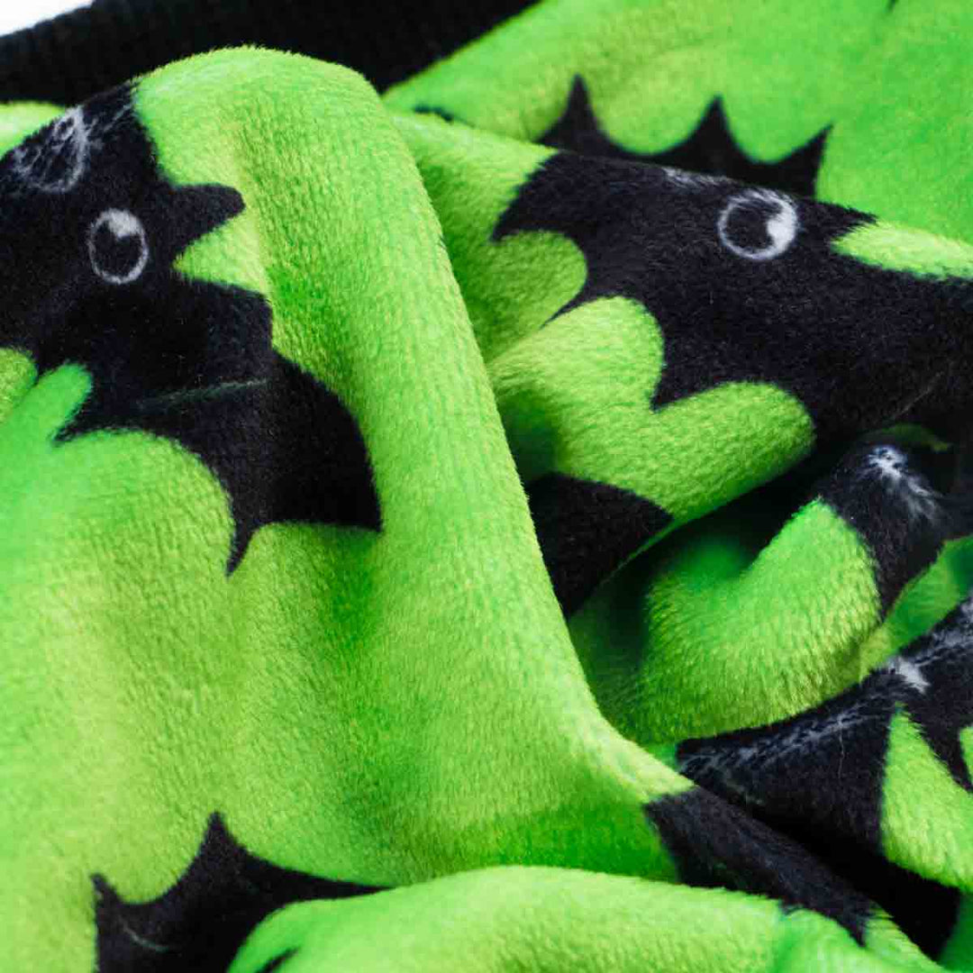 Soft, textured green fleece for dog pajamas featuring black cartoon bat prints, ideal for a cozy Halloween.