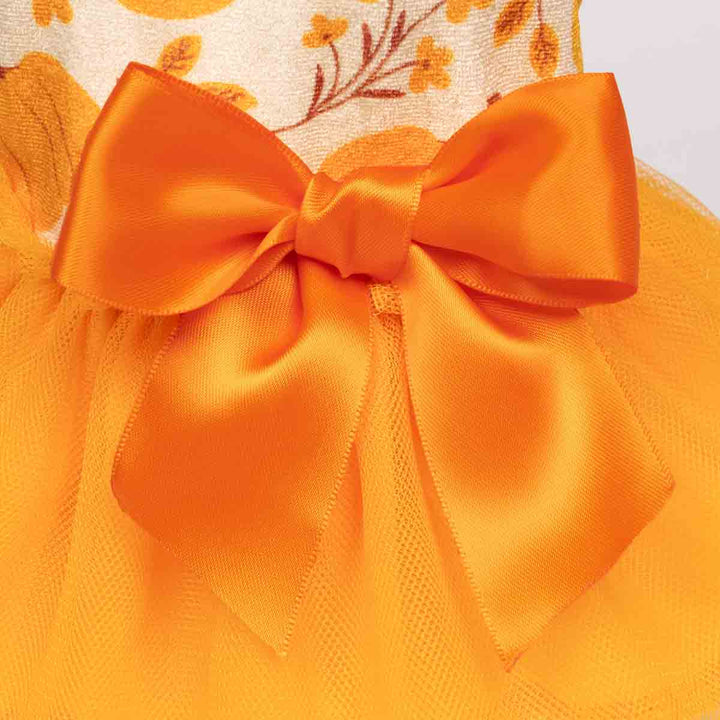 Dog dress with an orange satin bow and soft mesh layers, perfect for fall celebrations.