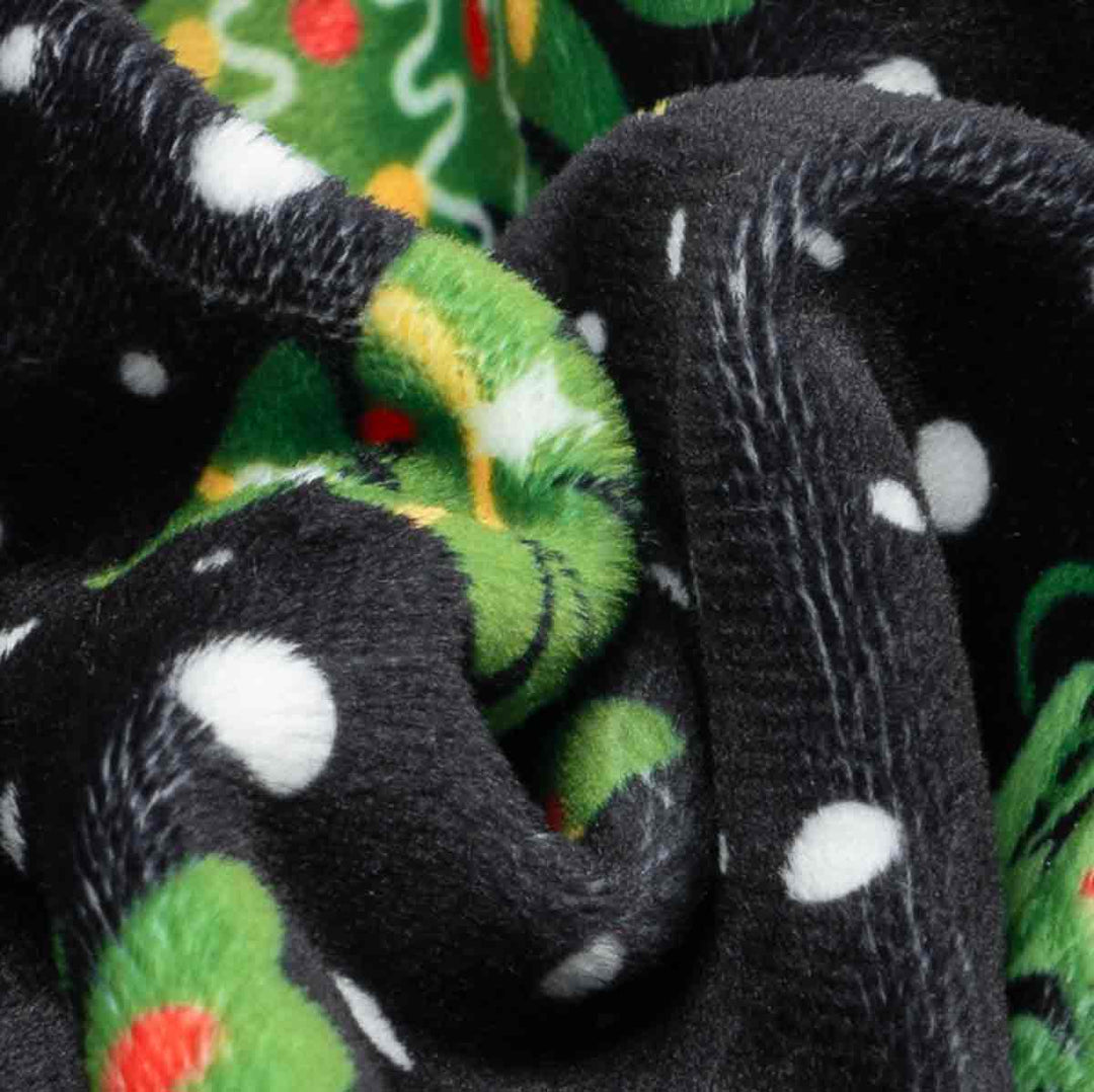 Close-up of soft fleece fabric with dog pajamas Christmas tree print.