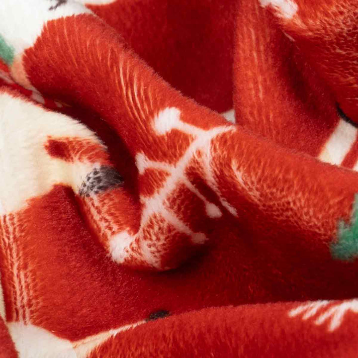 Close-up of red fabric with white patterns, possibly a blanket or towel.