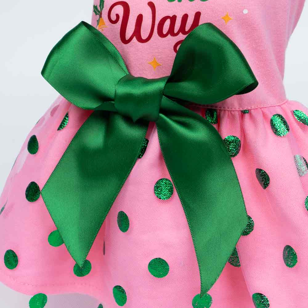 Close-up of green satin bow on pink dog dress with shiny green dots.
