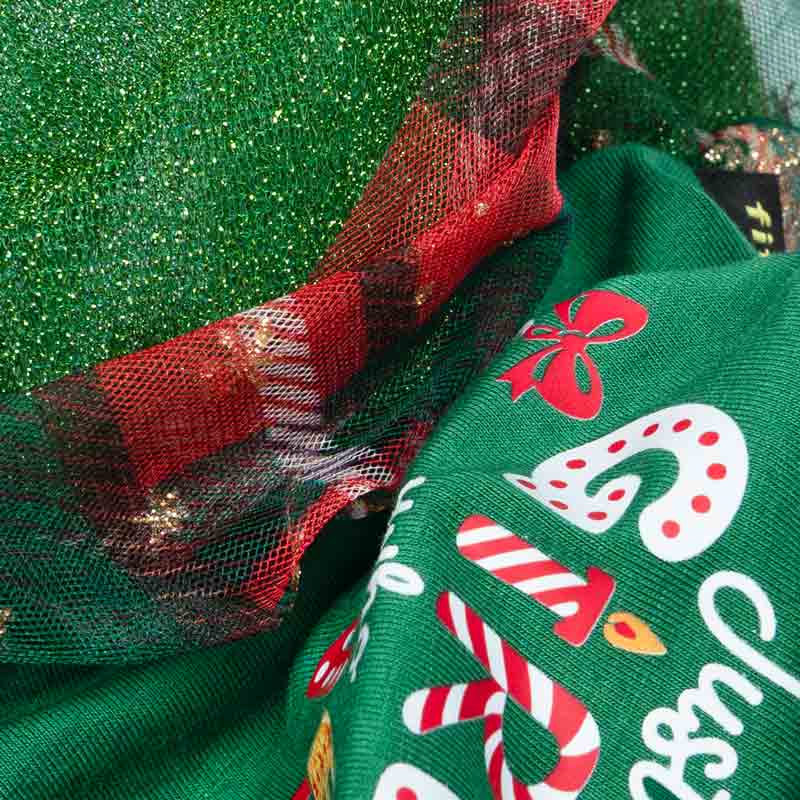 Fabric detail of dog dress showing green cotton blend with candy cane and glitter tulle overlay.