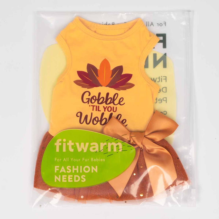 Thanksgiving dog dress with turkey feather print and bow, packaged in Fitwarm branded bag.