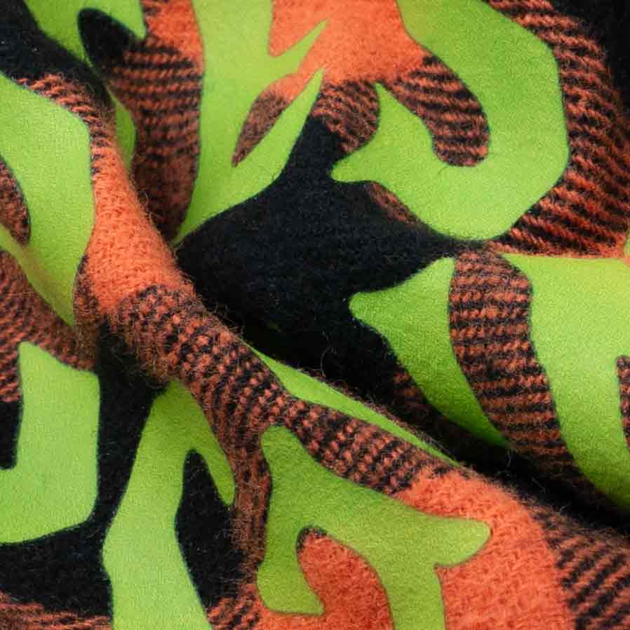 Close-up of soft plaid fabric with green lettering on Halloween dog bandanas.