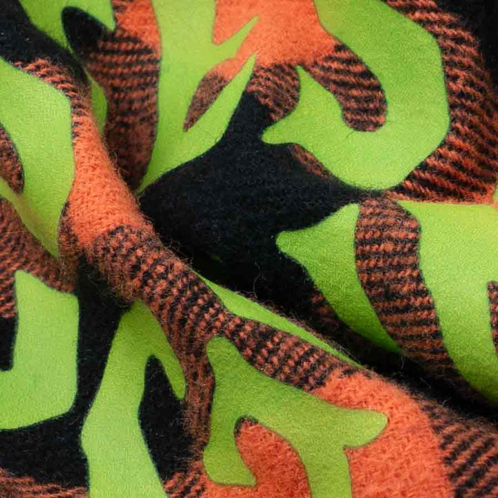 Close-up of soft plaid fabric with green lettering on Halloween dog bandanas.