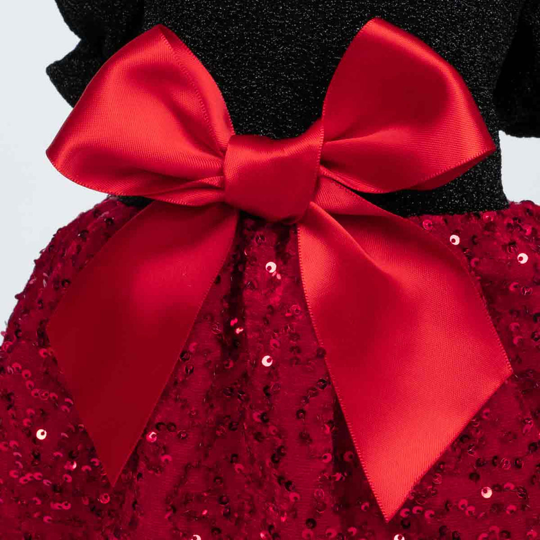 Close-up of elegant red satin bow on a black and red sequin dog dress.