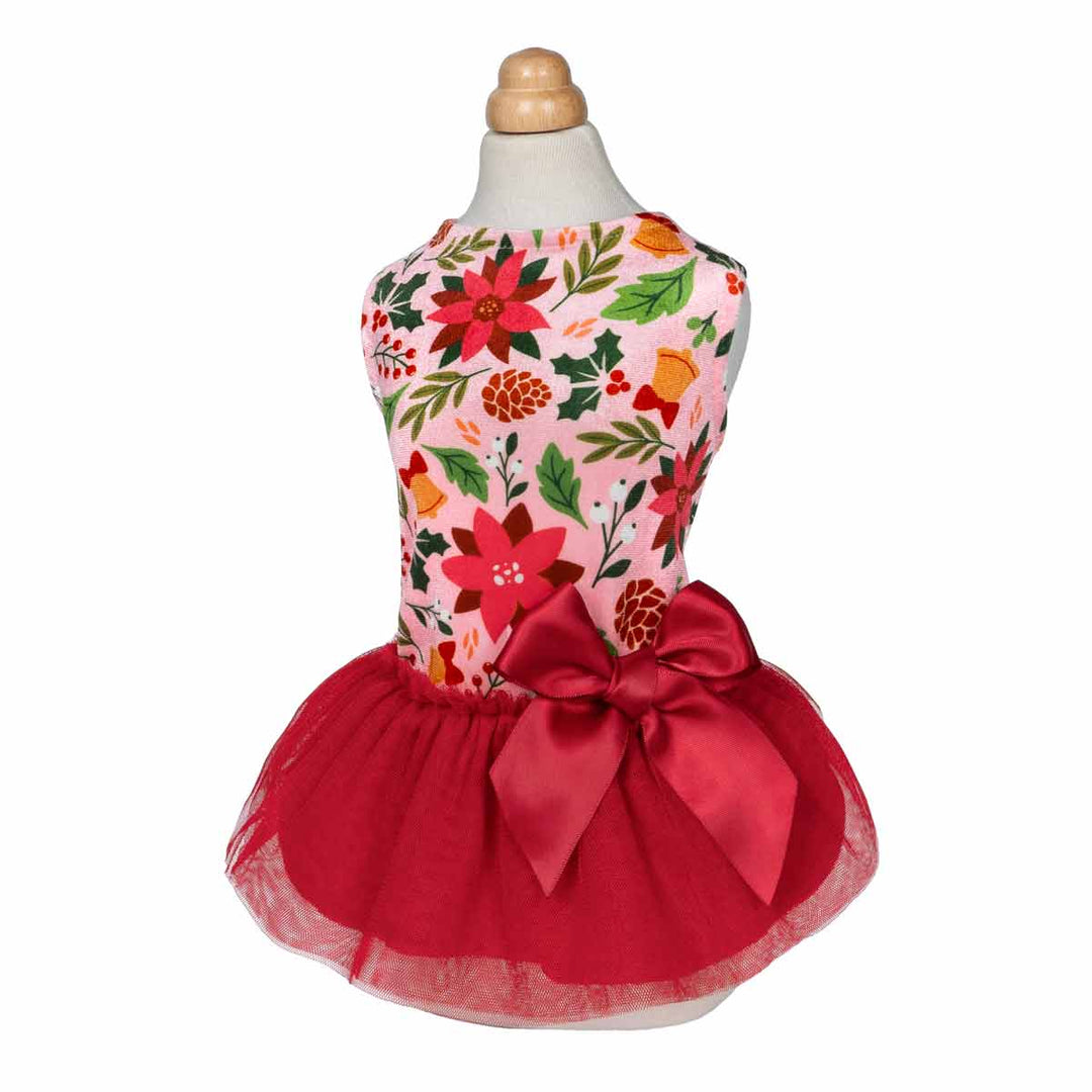 Mannequin wearing Christmas-themed dog dress with floral prints and red satin bow.