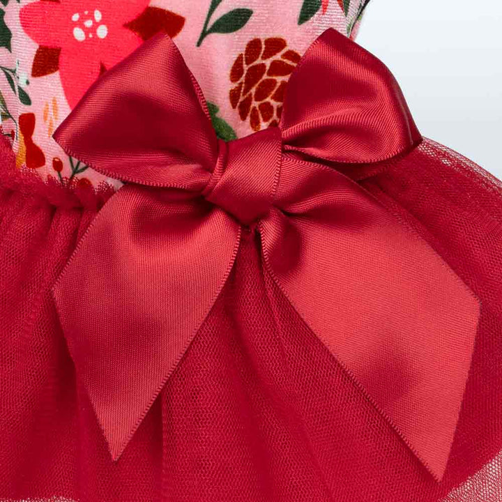 Close-up view of red satin bow on festive dog dress.