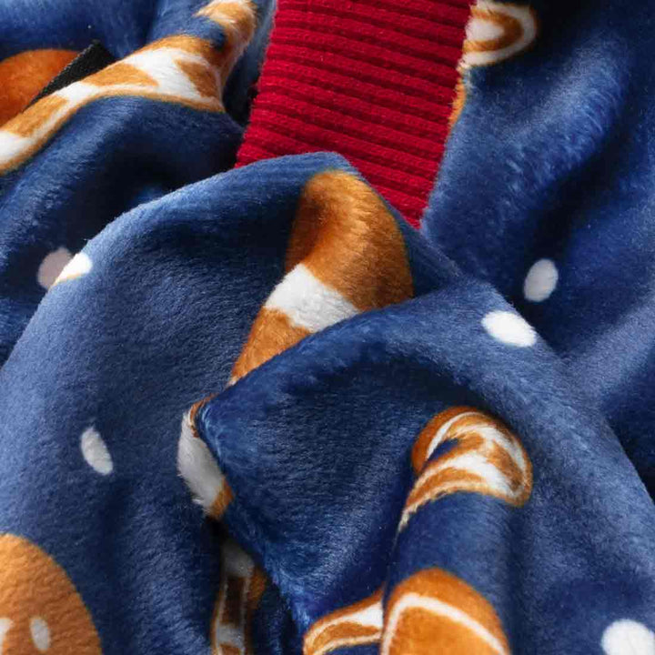 Close-up of blue velvet fabric from Christmas dog pajamas featuring gingerbread and candy designs.