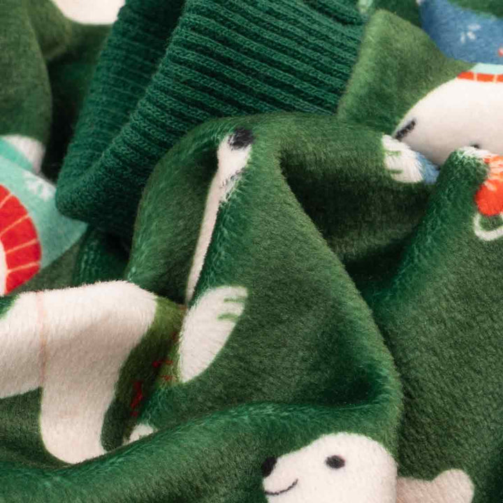 Close-up of soft velvet fabric from green dog pajamas with polar bear pattern.